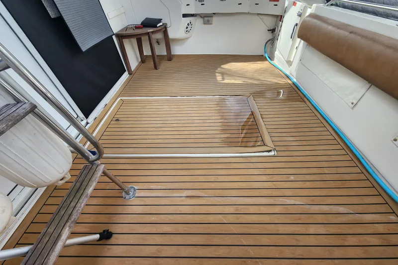 Slide: The Image of 1996 Sea Ray 370 Sedan Bridge deck with wooden flooring and seating area. - 4