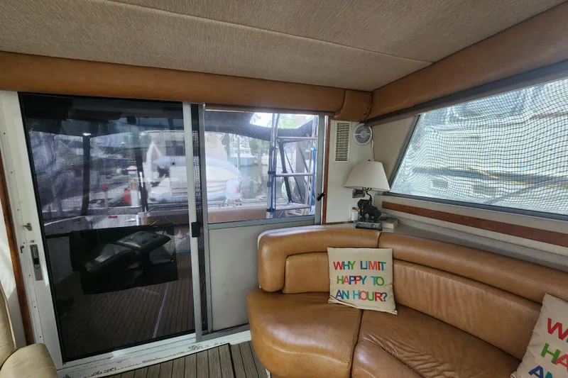 Slide: The Image of Interior of a 1996 Sea Ray 370 Sedan Bridge with cozy seating and decorative pillows. - 49