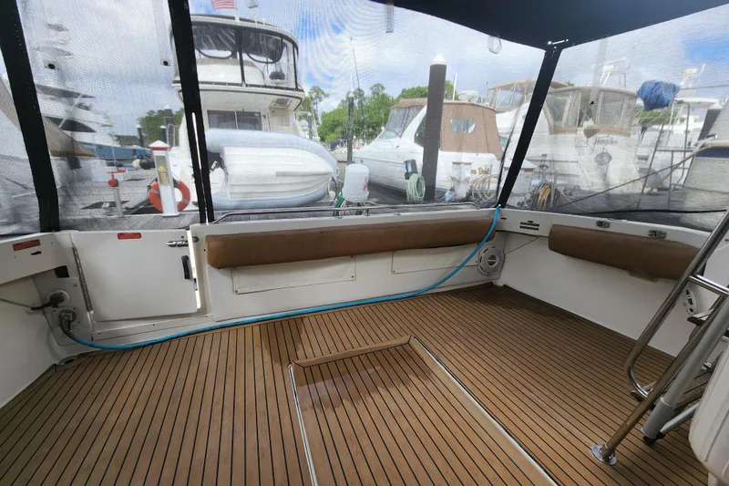 Slide: The Image of 1996 Sea Ray 370 Sedan Bridge cockpit with teak flooring and marina view. - 51