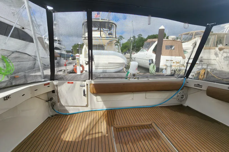 Slide: The Image of 1996 Sea Ray 370 Sedan Bridge interior with teak flooring, docked at marina. - 52