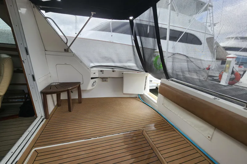 Slide: The Image of 1996 Sea Ray 370 Sedan Bridge interior with wooden deck and seating area. - 53