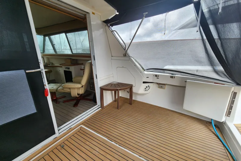 Slide: The Image of 1996 Sea Ray 370 Sedan Bridge interior with wooden deck and seating area. - 55