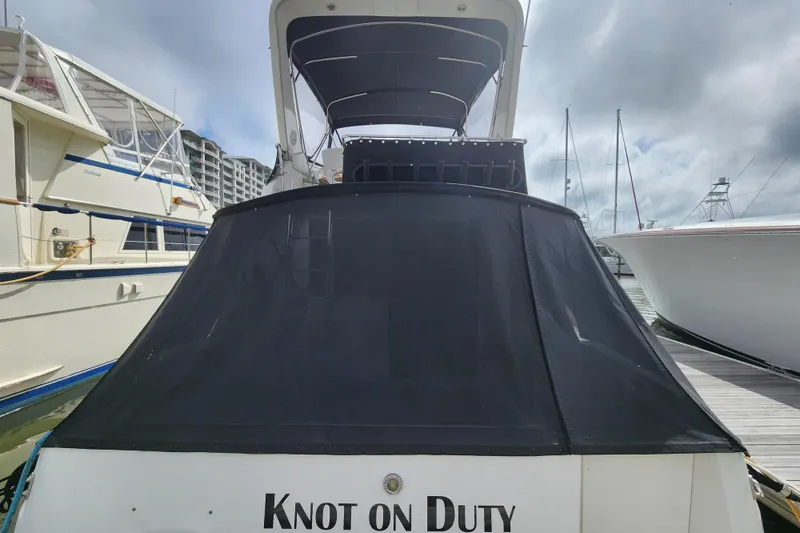 Slide: The Image of 1996 Sea Ray 370 Sedan Bridge yacht docked, rear view with "Knot on Duty" text. - 58