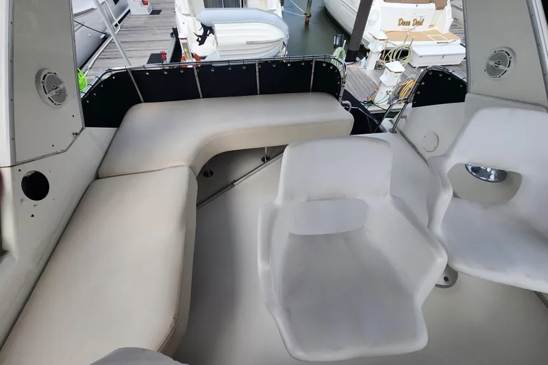 Slide: The Image of 1996 Sea Ray 370 Sedan Bridge interior with white seating and marina view. - 9