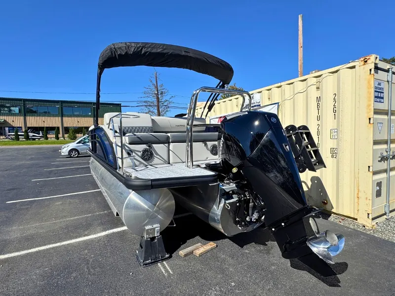 Slide: The Image of A 2027 Harris Cruiser 230 pontoon boat with a black canopy and outboard motor. - 4