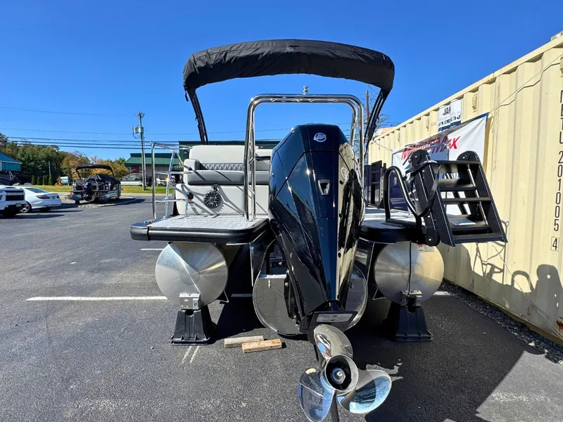 Slide: The Image of A 2027 Harris Cruiser 230 pontoon boat with a black outboard motor and sunshade. - 5