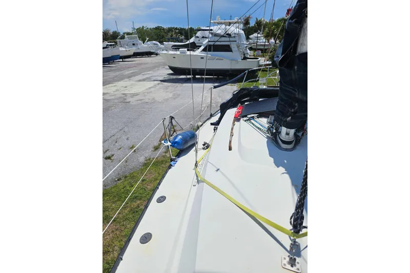 Slide: The Image of 1986 C & C 29 SL sailboat on land, surrounded by other boats. - 15