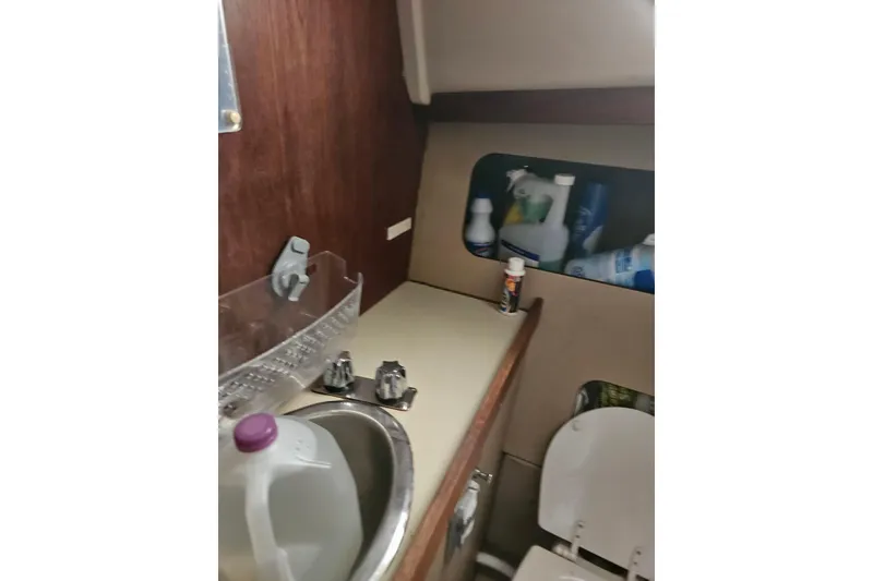 Slide: The Image of Interior of 1986 C & C 29 SL sailboat bathroom with sink and cleaning supplies. - 35