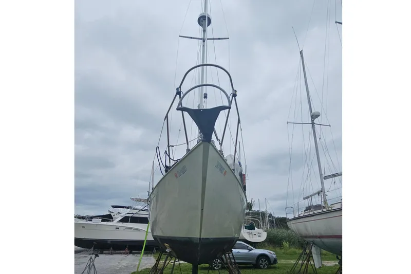 Slide: The Image of 1986 CNC 29 SL sailboat on stands, overcast sky, marina setting. - 4