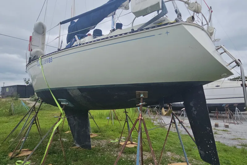 Slide: The Image of 1986 CNC 29 SL sailboat on stands, undergoing maintenance in a boatyard. - 5