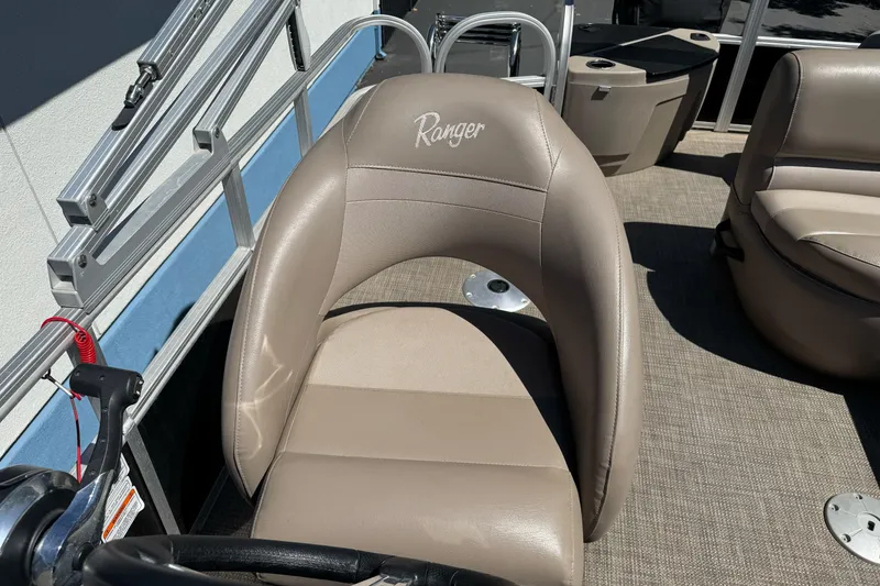 Slide: The Image of Ranger 200F 2020 boat seat with beige upholstery and steering wheel. - 14
