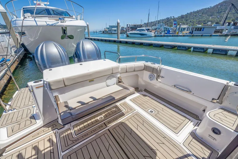 Slide: The Image of 2022 Cutwater C-32 CB boat docked, featuring spacious deck and twin engines. - 10