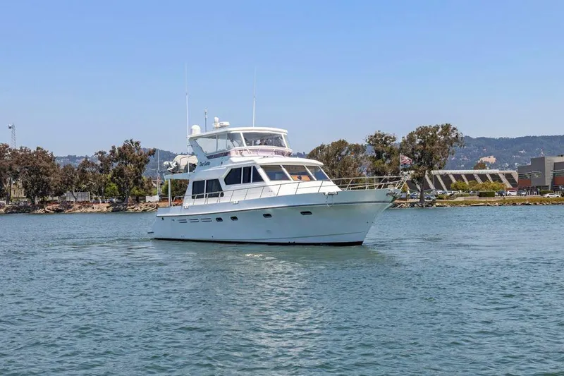 Slide: The Image of White 1999 Symbol 55 yacht cruising on a calm waterway. - 1