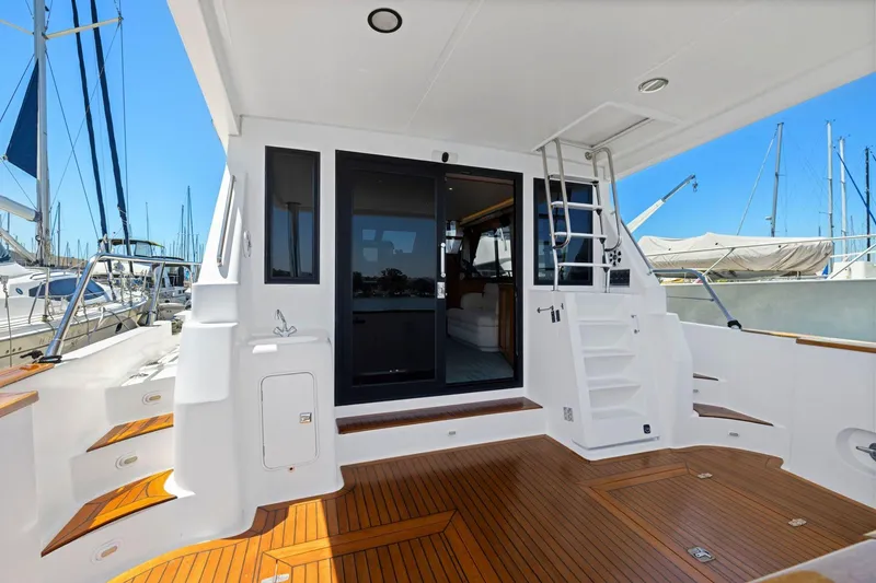 Slide: The Image of Spacious deck of 1999 Symbol 55 yacht with wooden flooring and marina view. - 13