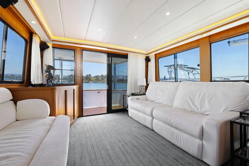 Slide: The Image of Luxurious yacht interior with white sofas, large windows, and scenic water views. Symbol 55, 1999 model. - 17