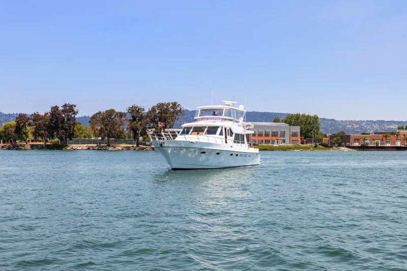 Slide: The Image of Luxury yacht Symbol 55, 1999 model, cruising on a serene waterway. - 2