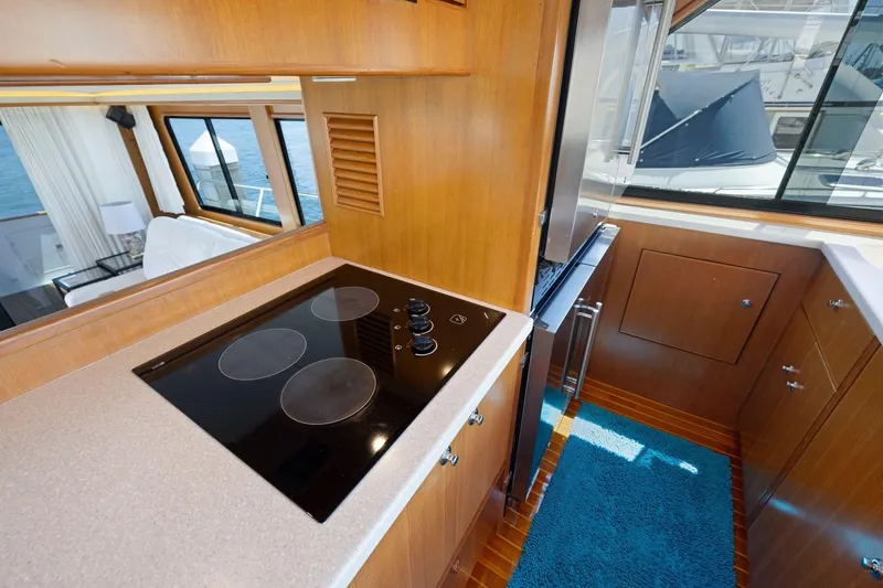 Slide: The Image of Luxurious yacht kitchen interior with modern stovetop, wood cabinetry, and ocean view. Symbol 55, 1999. - 23