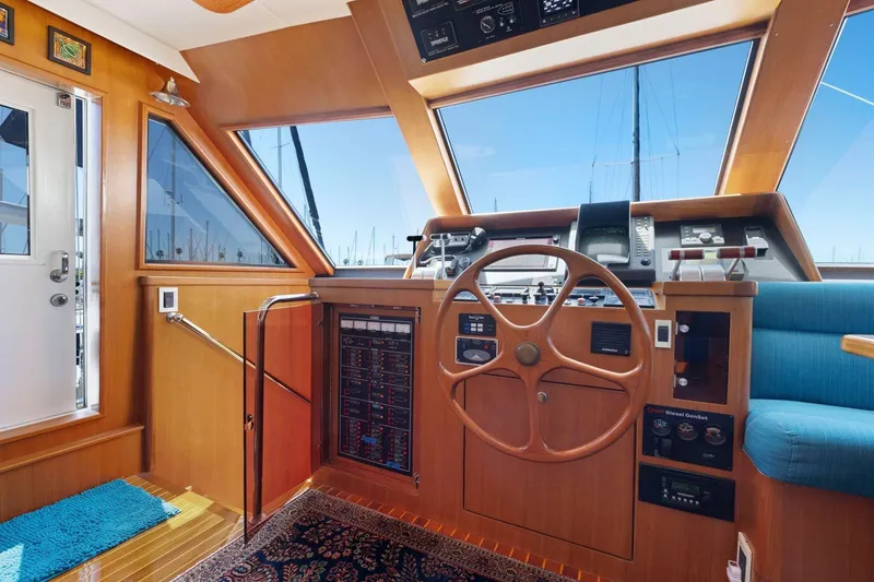 Slide: The Image of 1999 Symbol 55 yacht helm with wooden steering wheel and navigation controls. - 26