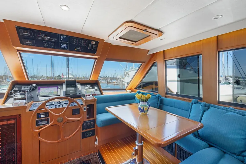 Slide: The Image of Luxurious 1999 Symbol 55 yacht interior with helm, blue seating, and marina view. - 27