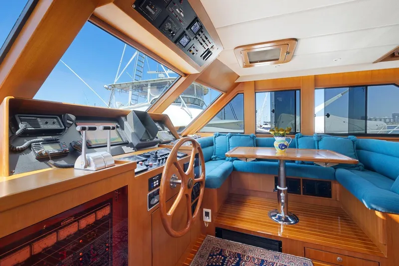Slide: The Image of Luxurious 1999 Symbol 55 yacht interior with wooden helm, blue seating, and panoramic windows. - 29