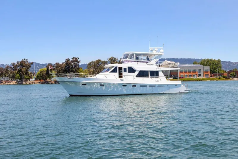Slide: The Image of 1999 Symbol 55 yacht cruising on a sunny day near a coastal building. - 3