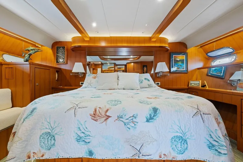 Slide: The Image of Luxurious yacht bedroom with nautical decor, featuring a starfish-patterned bedspread, wood paneling, and elegant lighting. - 39