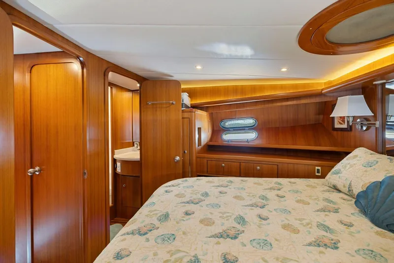 Slide: The Image of Luxurious 1999 Symbol 55 yacht cabin with wood paneling and cozy bedding. - 44