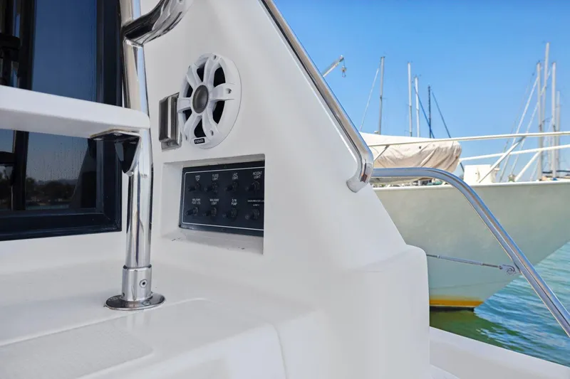 Slide: The Image of Control panel and speaker on a 1999 Symbol 55 yacht, docked with sailboats in the background. - 46