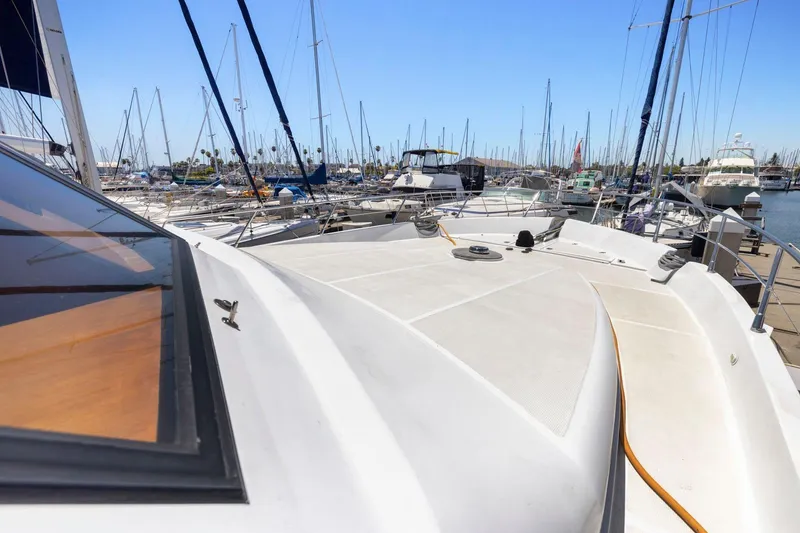 Slide: The Image of Bow view of a 1999 Symbol 55 yacht docked in a marina. - 49