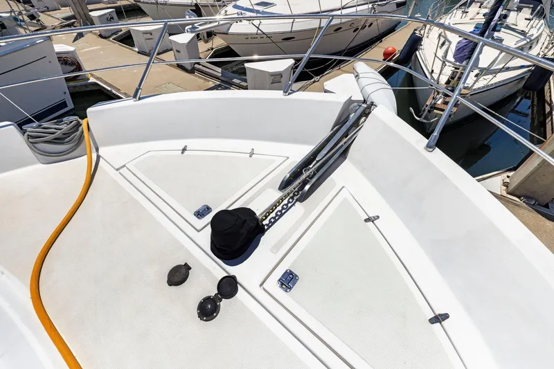 Slide: The Image of Bow of a 1999 Symbol 55 yacht docked at a marina with visible equipment. - 50