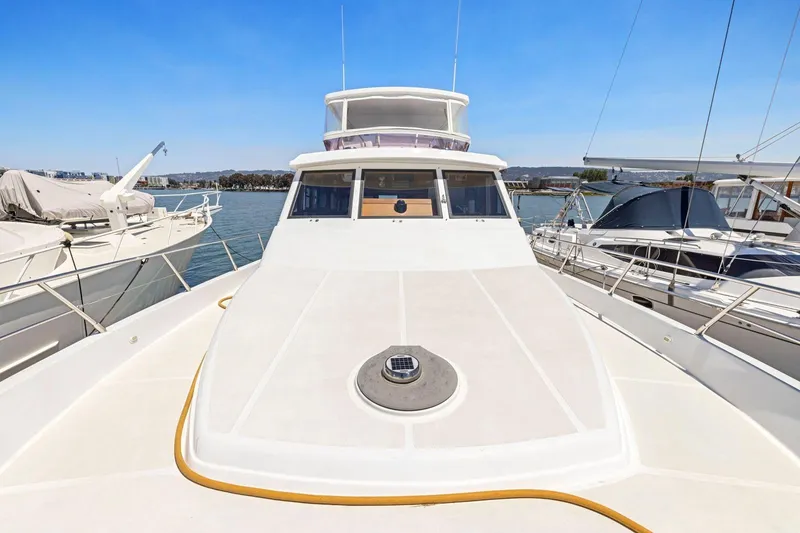 Slide: The Image of 1999 Symbol 55 yacht docked, showcasing sleek design and spacious deck. - 51