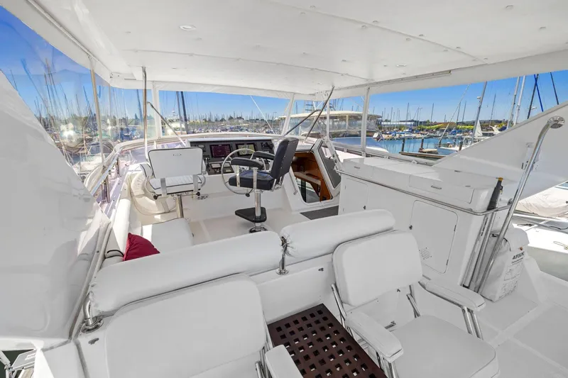 Slide: The Image of Luxurious 1999 Symbol 55 yacht interior with white seating and marina view. - 56