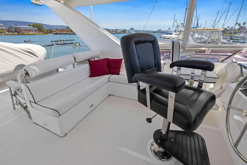 Slide: The Image of Luxurious yacht interior with black captain's chair and white seating, overlooking marina. Symbol 55, 1999. - 57