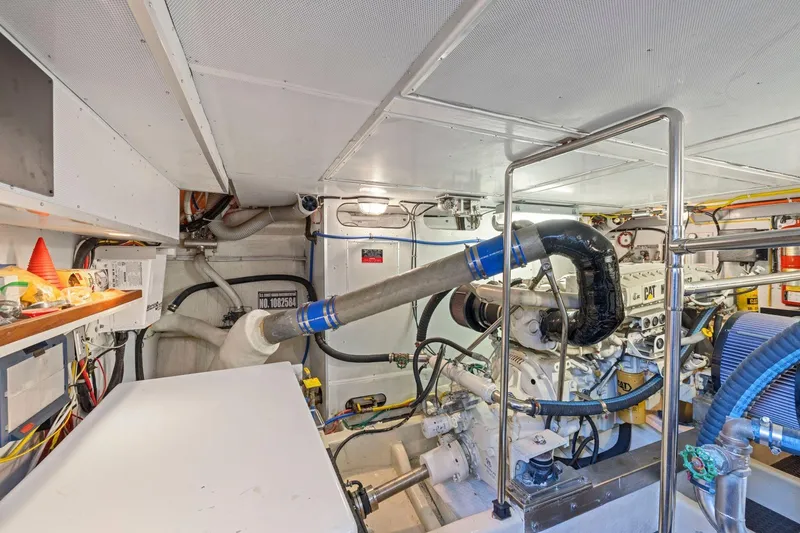 Slide: The Image of Engine room of a 1999 Symbol 55 yacht, featuring mechanical components and wiring. - 62