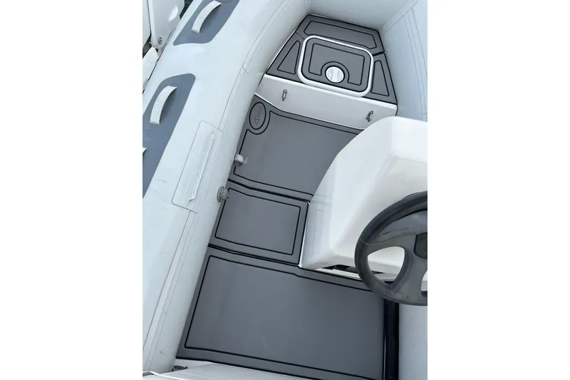 Slide: The Image of Interior of a 1999 Symbol 58 boat, featuring sleek gray flooring and seating. - 71