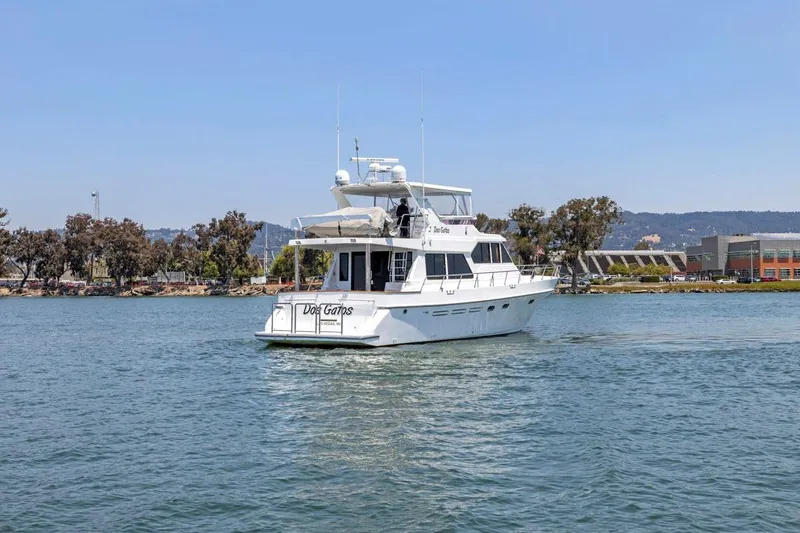 Slide: The Image of White 1999 Symbol 55 yacht cruising on a calm waterway, surrounded by trees and buildings. - 8