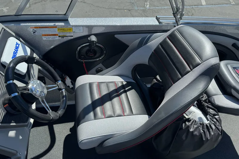 Slide: The Image of 2018 Ranger 1880MS boat interior with steering wheel and black leather seat. - 14