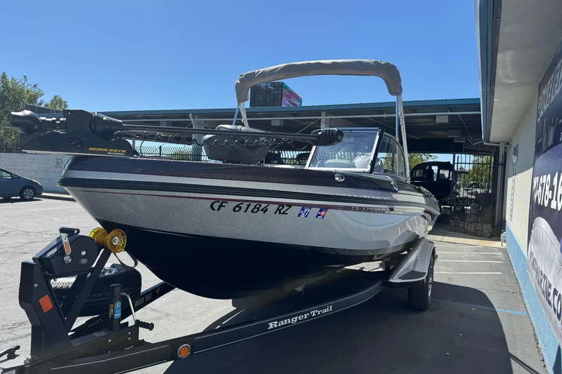 Slide: The Image of 2018 Ranger 1880MS boat on trailer, parked outdoors, featuring a trolling motor and canopy. - 5