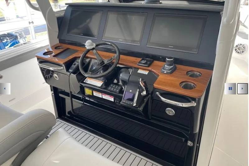 Slide: The Image of 2025 Everglades 395 Center Console helm with modern navigation screens and controls. - 7