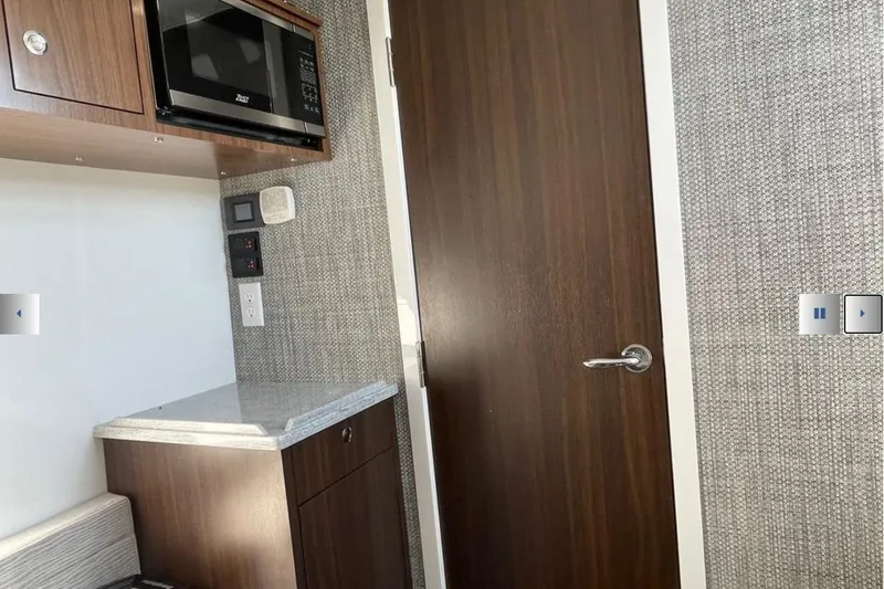 Slide: The Image of Interior of 2025 Everglades 395 Center Console with microwave and wooden cabinetry. - 8