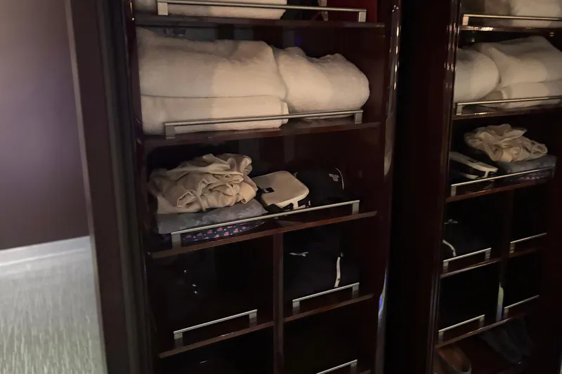 Slide: The Image of Luxury yacht Lazzara LSX 75 interior closet with neatly organized towels and clothing. - 14