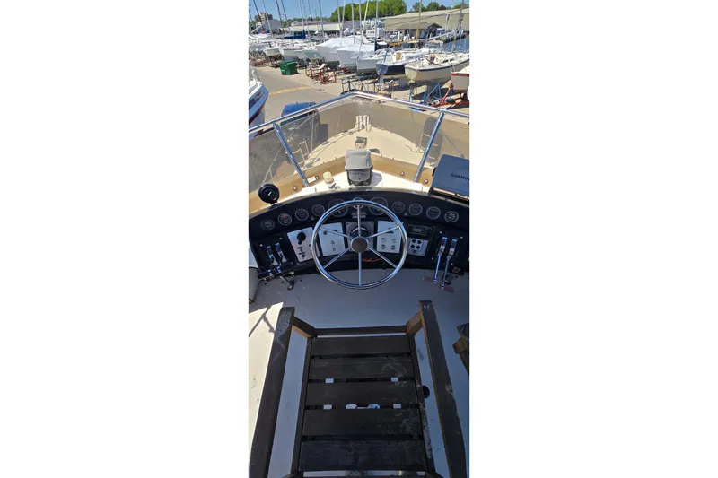 Slide: The Image of 1985 Carver 3207 Aft Cabin Motor Yacht helm with steering wheel and controls. - 10