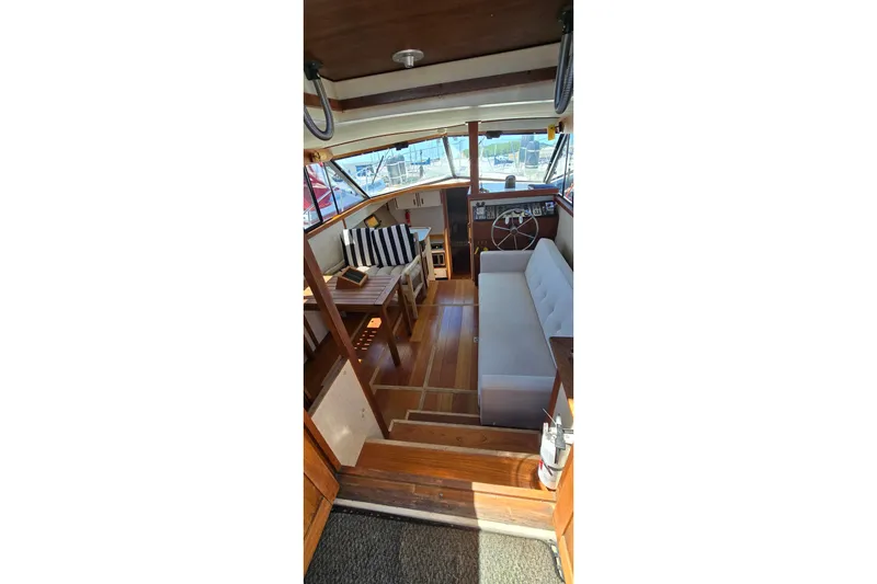 Slide: The Image of Interior of 1985 Carver 3207 Aft Cabin Motor Yacht with wooden flooring and seating area. - 11
