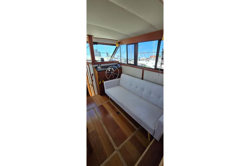 Slide: The Image of Interior of 1985 Carver 3207 Aft Cabin Motor Yacht with white sofa and wooden flooring. - 12