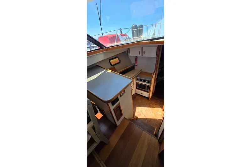 Slide: The Image of Interior of 1985 Carver 3207 Aft Cabin Motor Yacht with kitchen and wooden flooring. - 15