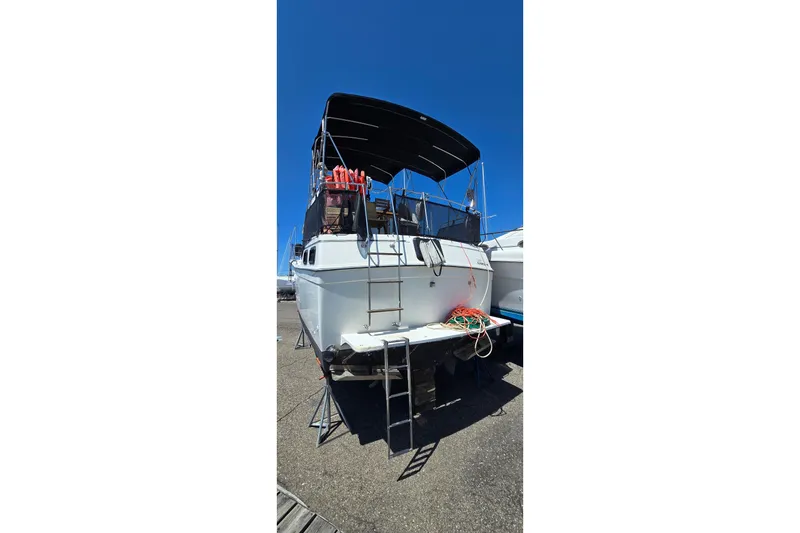 Slide: The Image of 1985 Carver 3207 Aft Cabin Motor Yacht on dry dock, with visible ladder and ropes. - 2