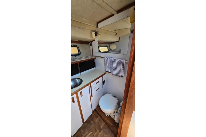 Slide: The Image of 1985 Carver 3207 Aft Cabin Motor Yacht bathroom with sink, toilet, and towel rack. - 20