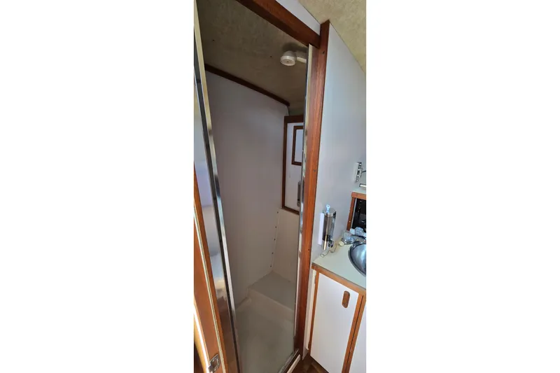 Slide: The Image of 1985 Carver 3207 Aft Cabin Motor Yacht interior, featuring a compact bathroom with wooden accents. - 21