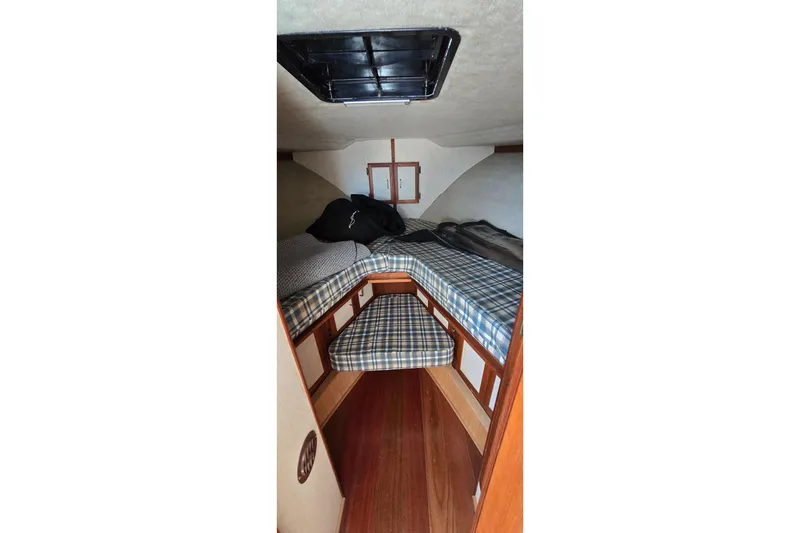 Slide: The Image of 1985 Carver 3207 Aft Cabin Motor Yacht interior with plaid bedding and wooden accents. - 22