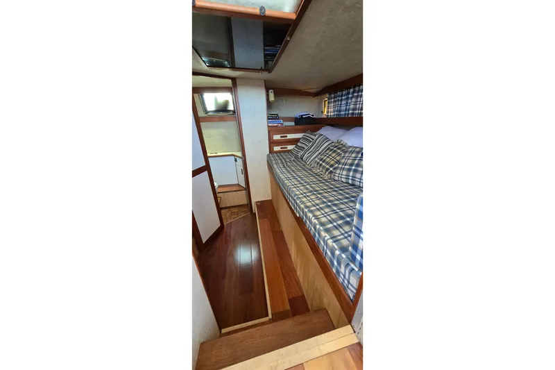 Slide: The Image of 1985 Carver 3207 Aft Cabin Motor Yacht interior with plaid bedding and wooden flooring. - 23